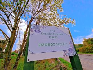 ein Schild für den immergrünen Gasthof bbb an der Seite einer Straße in der Unterkunft The Evergreen Inn in Banbury