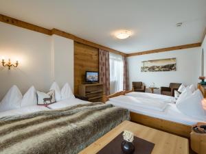 フューゲンにあるHotel Landhaus Zillertalのベッド2台とテレビが備わるホテルルームです。