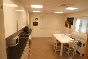 a classroom with a table and chairs and a whiteboard at Skrå hostel - bed & business in Släda