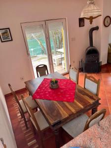 a dining room with a table and a wood stove at Holiday Homer Kuća na obali Vrbasa in Banja Luka