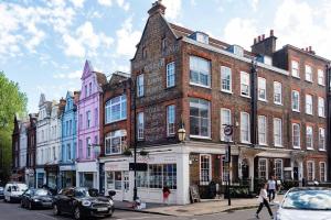 un grupo de edificios en una calle de la ciudad con coches en Hampstead High Flyer, en Londres