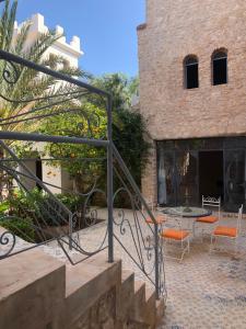 una escalera que conduce a un edificio con sillas de color naranja y una mesa en CHATEAU D'ORIENT, en Essaouira