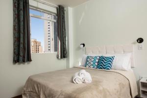 um quarto com uma cama com duas toalhas em Prédio central com apartamentos reformados em São Paulo