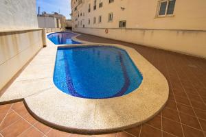 a large blue swimming pool in a building at Calpe Bay Apartment in Calpe