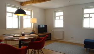 a living room with a table and chairs and a tv at Das Schindelhaus in Groß-Umstadt