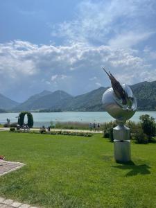 a statue of a bird on a ball in a park at Schliersee-Lounge in Schliersee