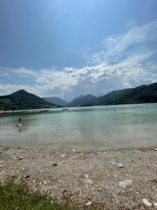 a person standing in the water on a beach at Schliersee-Lounge in Schliersee