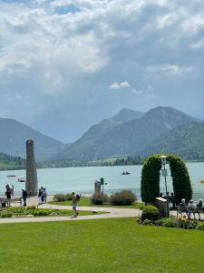 a group of people walking on a sidewalk near a body of water at Schliersee-Lounge in Schliersee