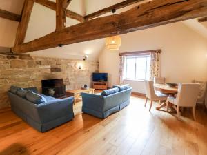 a living room with couches and a dining room table at Tithe Barn in Derby