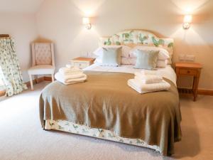 a bedroom with a large bed with towels on it at Tithe Barn in Derby