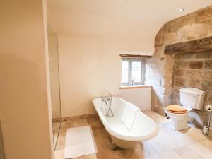 a bathroom with a bath tub and a toilet at Tithe Barn in Derby +31 photos