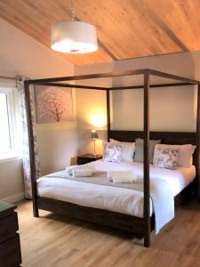a bedroom with a canopy bed in a room at Breckland Lodge 2 with Hot Tub in Belladrum