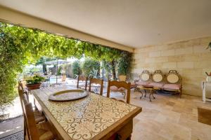 a dining room with a table and chairs and a patio at Le Castel de Castillon - Maison d'exception à 10 minutes de Saint Emilion in Castillon-la-Bataille