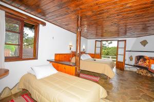 um quarto com 2 camas e uma lareira em Hotel Cabeça de Boi em Monte Verde