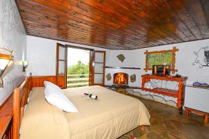 um quarto com uma cama grande e uma lareira em Hotel Cabeça de Boi em Monte Verde