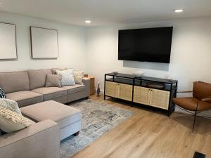 uma sala de estar com um sofá e uma televisão de ecrã plano em Siren of the Cape - Fully Renovated in 2023 em Cape Charles