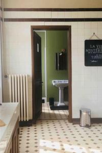 a bathroom with a sink and a door leading to a toilet at L Annexe appartement entier in Auxi-le-Château +3 photos