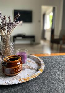 talerz ze świecą i wazon z kwiatami na stole w obiekcie DolceVita - Gorzyce w mieście Gorzyce