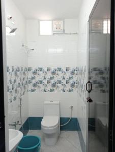 a bathroom with a toilet and a sink and a shower at Variyar Service Apartments Unit E 2nd Floor in Vellore +3 photos