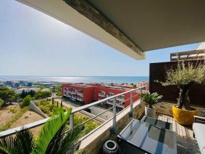a balcony with a red train on the tracks at ''Le Soleil'' Superbe T3 avec vue étang et mer, clim parking et piscine in Sète
