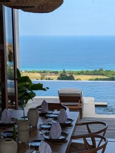 a dining table with a view of the ocean at Umarato Villa Sumba in Rua