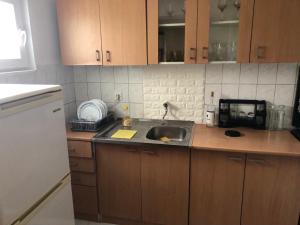 una cocina con armarios de madera y fregadero en Guesthouse STAR en Mostar