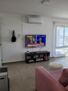 ein Wohnzimmer mit einem Flachbild-TV an der Wand in der Unterkunft Casa Amplia y Tranquila con Garage in Alta Gracia