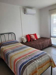 ein Schlafzimmer mit einem Bett und einem Sofa in der Unterkunft Casa Amplia y Tranquila con Garage in Alta Gracia