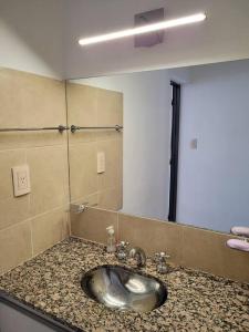 ein Badezimmer mit einem Waschbecken und einem großen Spiegel in der Unterkunft Casa Amplia y Tranquila con Garage in Alta Gracia