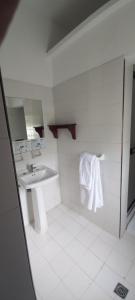 a white bathroom with a sink and a mirror at Hotel Silvia by Destino Pacifico in Silvia