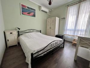 um quarto com uma cama, uma cómoda e uma janela em The Bookies Apartments em Sófia