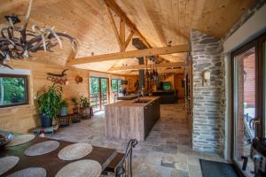 a kitchen and dining room of a cabin with wooden ceilings at Chalet : le moulin du sagard in Wisches