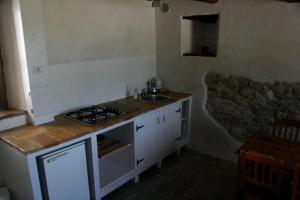 een kleine keuken met een fornuis en een wastafel bij I Magnoni in Pergola