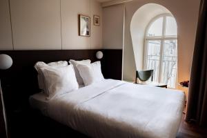 Hôtel Cabane - Orso Hotels في باريس: غرفة نوم مع سرير أبيض كبير مع نافذة