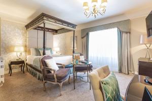 ein Hotelzimmer mit einem Bett, einem Tisch und Stühlen in der Unterkunft The Swan Hotel, Wells, Somerset in Wells