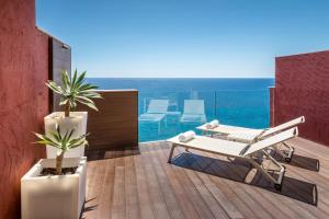 a balcony with chairs and a view of the ocean at Occidental Pueblo Acantilado in El Campello