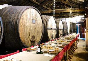a long table in a wine cellar with barrels at Casa Dos Varais, Manor House in Lamego