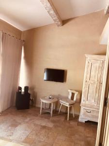 uma sala de estar com uma mesa e uma televisão na parede em Villa Alba em Saint-Tropez