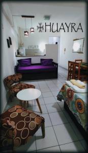 Una sala de estar con un sofá, una mesa y sillas. en Edificio Huayra, en La Rioja