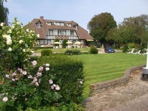a large house with a yard with pink flowers at Golf Hotel in Le Tr&eacute;port