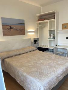 a bedroom with a large bed and a kitchen at Hotel Marea in Grado