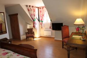 a living room with a bed and a table and a television at Golf Hotel in Le Tréport