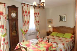 a bedroom with a bed with a table and a clock at Golf Hotel in Le Tr&eacute;port