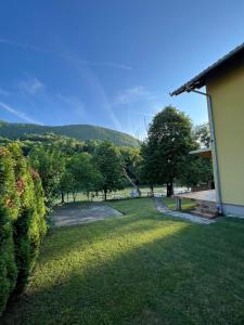 vistas a un patio con árboles y una casa en Holiday Homer Kuća na obali Vrbasa en Banja Luka