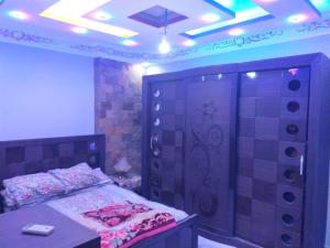 1 dormitorio con cama, armario grande y luces en شقه فندقيه, en El Cairo