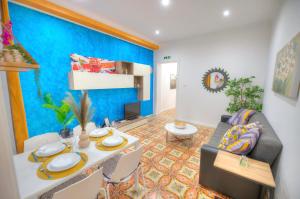 sala de estar con mesa y pared azul en Charming 2 bedroom townhouse, internal yard JDES1-1, en Il-Gżira