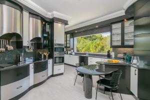 a kitchen with a table and chairs and a window at BS1 - Pezula Exclusive Elegance in Knysna