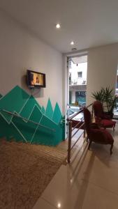 Habitación con mesa, silla y TV. en Hostel Che Boutique en Buenos Aires