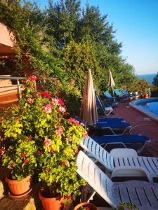 a row of chairs and flowers next to a swimming pool at Seaview apt. 3 complex Karia in Kavarna