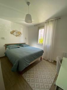 a bedroom with a bed and a window at Port Marianne City Cosy Apparemment in Montpellier